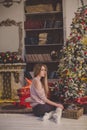 Beautiful young woman in a Christmas interior. Dressing a Christmas tree.