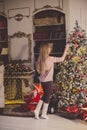 Beautiful young woman in a Christmas interior. Dressing a Christmas tree.