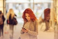 Beautiful young woman in the city, mall is busy with her mobile phone, talking, smiling Royalty Free Stock Photo