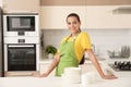 Beautiful young woman with clean dishes and cups at table Royalty Free Stock Photo