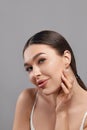 Beautiful young woman with clean face. Portrait of beauty model with clean perfect skin touching her face. Spa, skin care and well Royalty Free Stock Photo