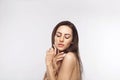 Beautiful young woman with clean perfect skin. Portrait of beauty model with natural nude make up and touching her face. Royalty Free Stock Photo