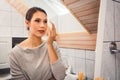 Beautiful young woman cleaning make up off her face using a cotton pad Royalty Free Stock Photo