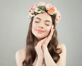 Beautiful young woman with clear skin portrait. Pretty girl with long curly hair and flowers. Royalty Free Stock Photo