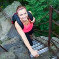 Beautiful young woman climbing a ladder in natural/national park Royalty Free Stock Photo