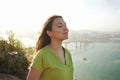 Beautiful young woman with closed eyes breathing with wind on her face relaxing enjoying sun at sunset. Beauty sunshine girl side Royalty Free Stock Photo