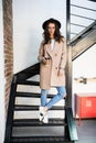 Portrait of woman wearing a coat. Beautiful young woman in coat descending steps in modern interior. Woman in casual style coat on Royalty Free Stock Photo