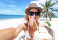 Beautiful young woman with a coconut in her hands makes selfie o Royalty Free Stock Photo