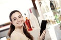 Beautiful young woman at the coffee bar, ice cream shop or pastry shop holding a black menu on her hands smiles at the camera. Royalty Free Stock Photo