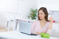 Beautiful young woman with coffee using laptop in kitchen Royalty Free Stock Photo