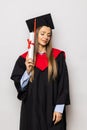 Beautiful young woman college graduate portrait wearing cap and gown with diploma isolated on white background Royalty Free Stock Photo