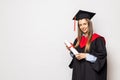 Beautiful young woman college graduate portrait wearing cap and gown with diploma isolated on white background Royalty Free Stock Photo