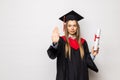 Beautiful young woman college graduate portrait wearing cap and gown with diploma isolated on white background Royalty Free Stock Photo