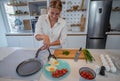 Beautiful young woman cooking in a modern kitchen. Royalty Free Stock Photo