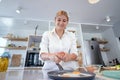 Beautiful young woman cooking in a modern kitchen. Royalty Free Stock Photo