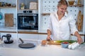 Beautiful young woman cooking in a modern kitchen. Royalty Free Stock Photo