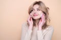 Beautiful young woman with cotton pad, applying lotion on face, removing makeup. Skin care. Studio portrait of girl Royalty Free Stock Photo