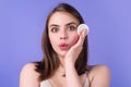 Beautiful young woman with cotton pad, applying lotion on face, removing makeup. Skin care. Studio portrait of girl Royalty Free Stock Photo