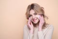 Beautiful young woman with cotton pad, applying lotion on face, removing makeup. Skin care. Studio portrait of girl Royalty Free Stock Photo