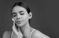 Beautiful young woman with cotton pad removing makeup. Skin care. Studio portrait of girl cleaning her face with cotton Royalty Free Stock Photo