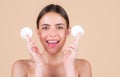 Beautiful young woman with cotton pad removing makeup. Skin care. Studio portrait of girl cleaning her face with cotton Royalty Free Stock Photo