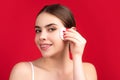 Beautiful young woman with cotton pad removing makeup. Skin care. Studio portrait of girl cleaning her face with cotton Royalty Free Stock Photo