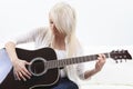 Beautiful young woman on the couch with a guitar