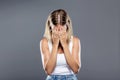 Beautiful young woman covering her face over gray background. Royalty Free Stock Photo