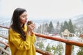 Beautiful young woman with cup of coffee on winter background Royalty Free Stock Photo