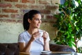 Beautiful young woman with cup of coffee. Woman enjoys fresh coffee in the morning with sunrise at coffe shop beautiful woman Royalty Free Stock Photo