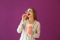 Beautiful young woman with cup of popcorn and 3D cinema glasses on color background Royalty Free Stock Photo