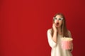 Beautiful young woman with cup of popcorn and 3D cinema glasses on color background Royalty Free Stock Photo