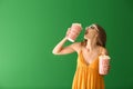 Beautiful young woman with cups of popcorn and 3D cinema glasses on color background Royalty Free Stock Photo