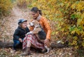 beautiful young woman with a cute boy walk a beagle dog in the autumn park Royalty Free Stock Photo