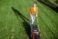 Woman cutting grass with lawn mower Royalty Free Stock Photo