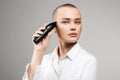 Beautiful young woman cutting her hair. bald Girl with hairclipper Royalty Free Stock Photo