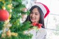 Beautiful young woman decorating xmas ornament on Christmas tree for Christmas and New Year holiday Royalty Free Stock Photo