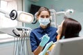 The beautiful young woman is at the dentist. She sits in the dentist`s chair and the dentist carefully examines the patient`s