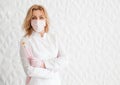 Beautiful young woman doctor beautician in a white uniform and a protective mask on her face posing with brushes in her hands Royalty Free Stock Photo