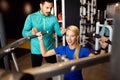 Beautiful woman doing exercises in gym with personal trainer Royalty Free Stock Photo