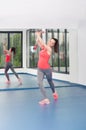 Beautiful young woman doing gimnastics on the floor with maces Royalty Free Stock Photo