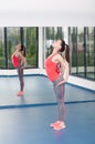 Beautiful young woman doing gimnastics on the floor with maces Royalty Free Stock Photo