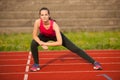 Beautiful young woman doing longe step on athletic track Royalty Free Stock Photo