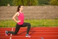 Beautiful young woman doing longe step on athletic track Royalty Free Stock Photo