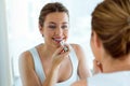 Beautiful young woman doing make-up near mirror at home. Royalty Free Stock Photo