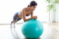 Beautiful young woman doing pilate exercise with fitness ball at home.