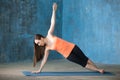 Beautiful young woman doing side plank pose