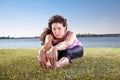 Beautiful young woman doing stretching exercise on green grass. Royalty Free Stock Photo