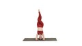 Beautiful young woman doing yoga exercise variation of supported headstand, garuda salamba sirsasana with crossed legs