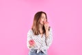 Beautiful young woman with donuts on pink background